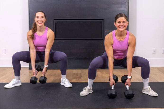 two women performing a wide sumo squat with dumbbells as part of the best exercises to tone the inner thighs