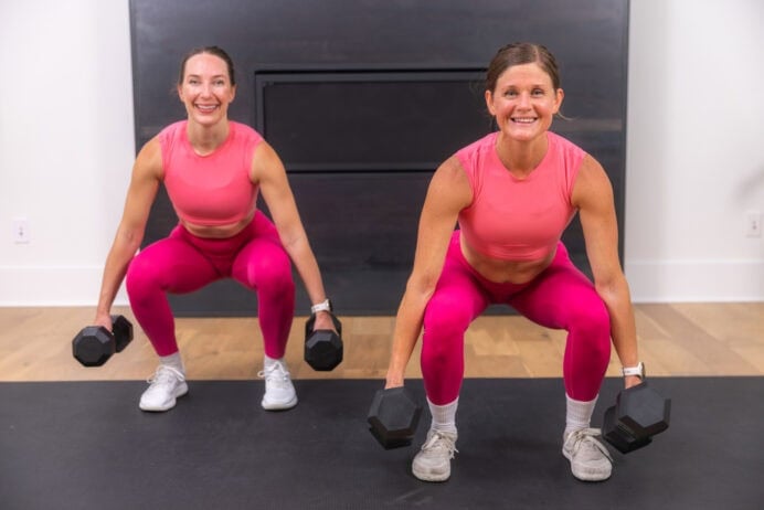 two women performing a squat with dumbbells in a full body strength and conditioning workout at home