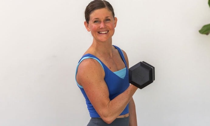 woman flexing as part of arm workout with dumbbells