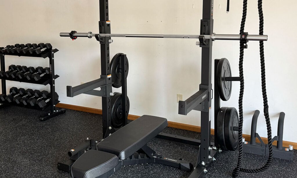 example of garage gym idea with squat rack and dumbbells