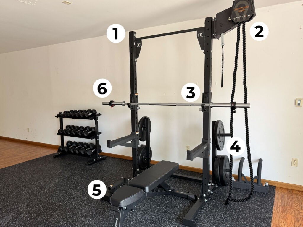 Squat rack in home gym shown with recommended accessories
