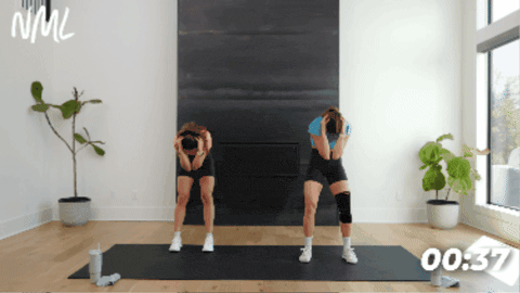 women demonstrating ad standing cat/cow as part of active recovery workout