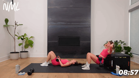 two women demonstrating how to perform dumbbell hip thrusts or glute bridges in an at home glute workout
