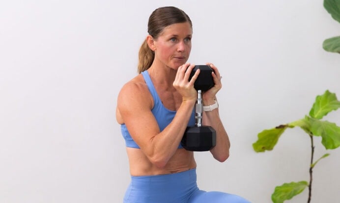 woman performing goblet march as example of dumbbell ab exercises
