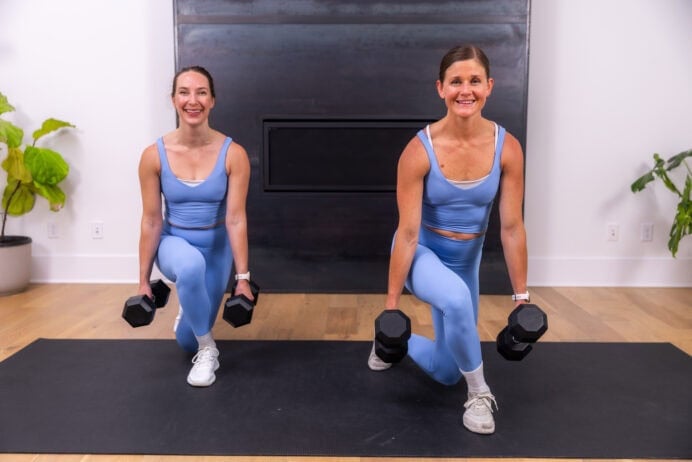 two women performing curtsy lunges with dumbbells in a full body strength workout