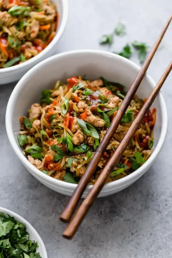 Egg Roll in a Bowl with ground turkey, green onions, cole slaw in a small white bowl. 