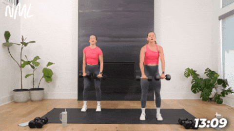 two women performing a front raise with dumbbells