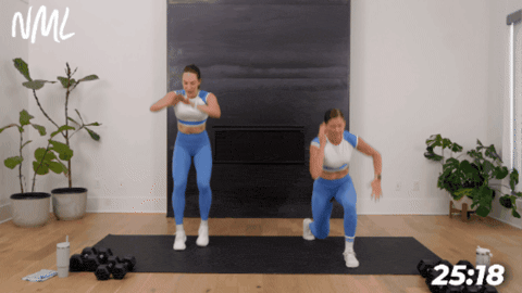 standing women performing jump lunges as example of hiit exercise at home
