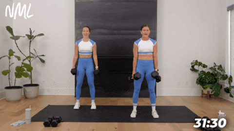 standing women performing squats as  part of 30 minute hiit workout at home