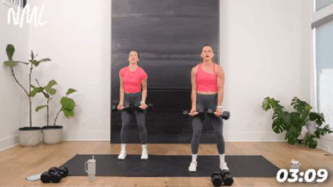 women performing a chest fly from a standing position