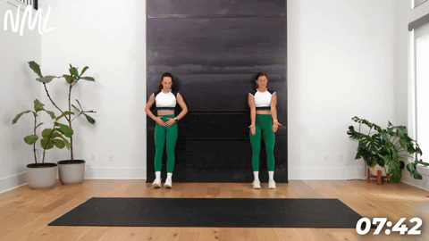 two women demonstrating anterior tib raises as part of leg stretches before a workout