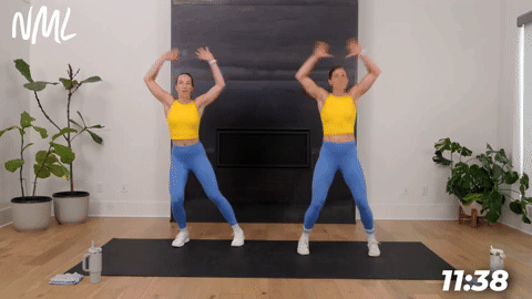 two women demonstrating jumping jacks in a bodyweight cardio workout