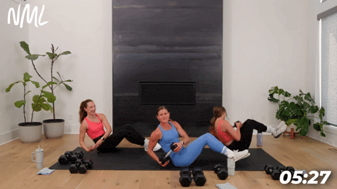 three women performing a seated twist in a 20 minute strength workout