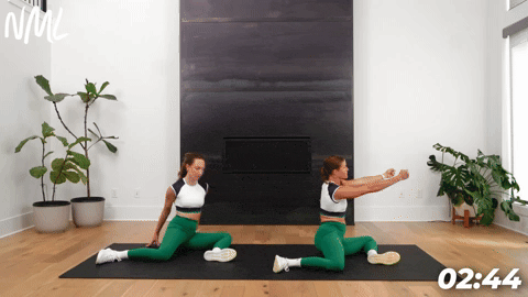 two women demonstrating 90 90 hip rotations as part of leg stretches before a workout