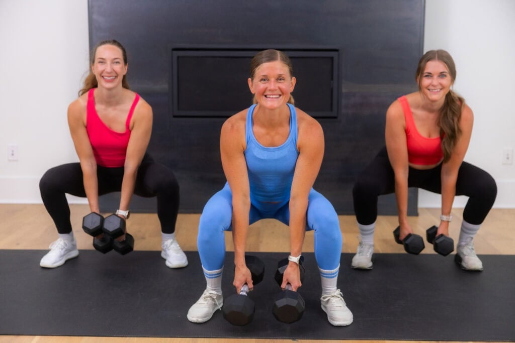 three women performing a wide squat in a 20 minute strength workout