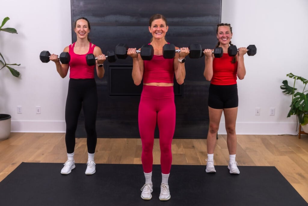 three women performing a dumbbell bicep curl in a full body at home circuit workout