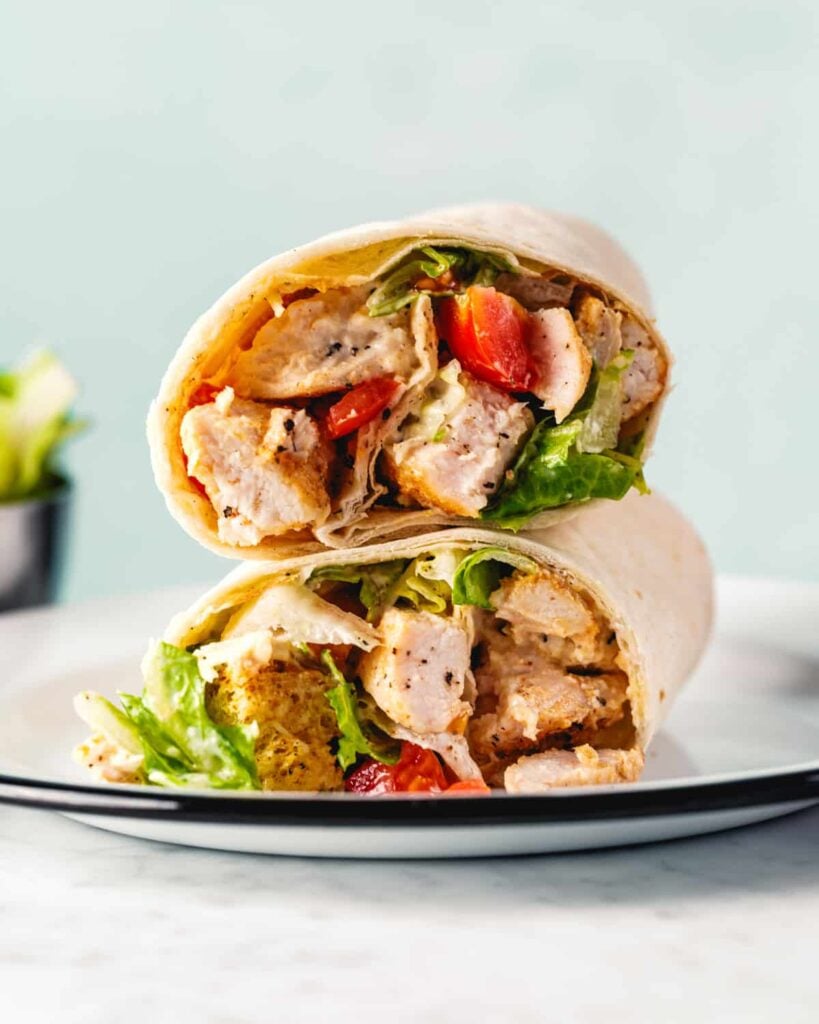 Homemade chicken caesar wrap with lettuce, grilled chicken, cheese and tomatoes.