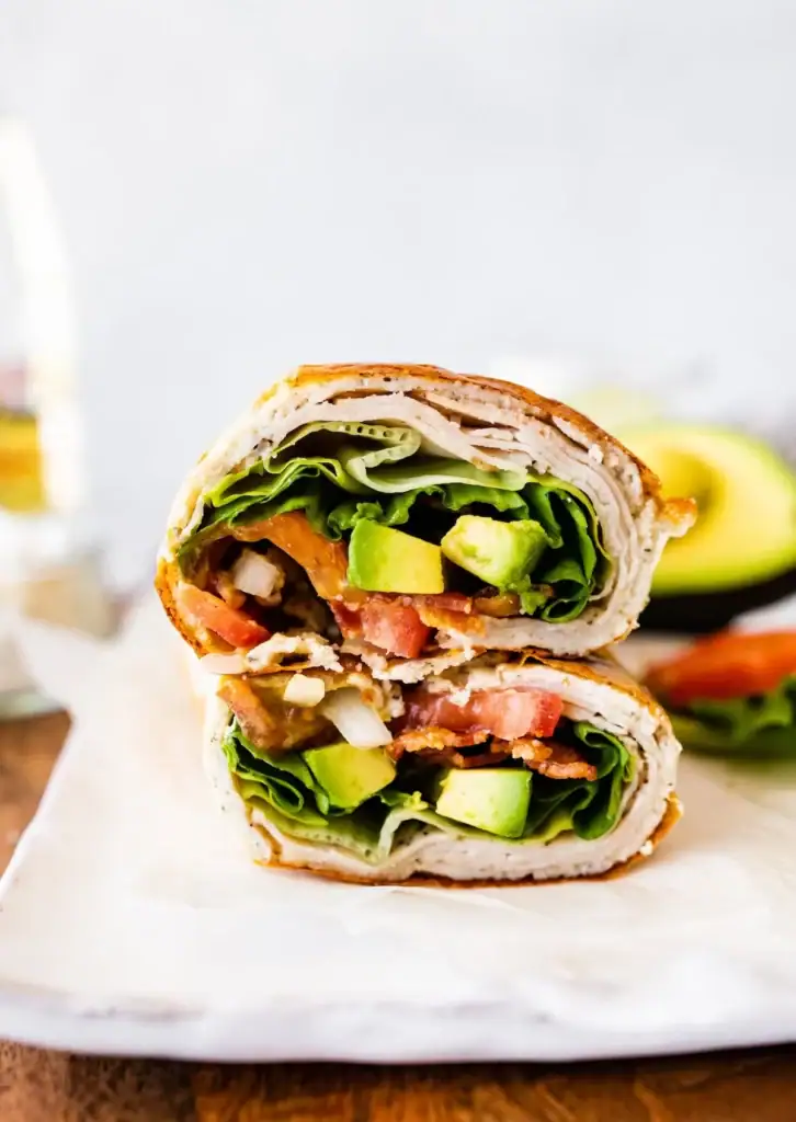 Cottage cheese wrap with turkey, lettuce, avocado, bacon and tomatoes.