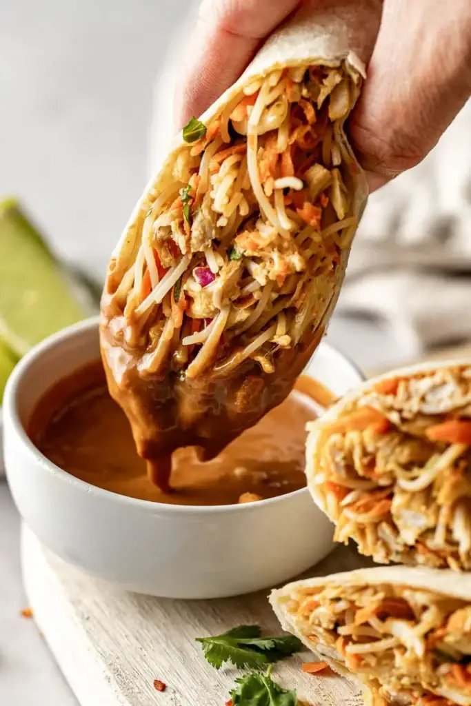 Peanut Chicken Wraps with shredded chicken, coleslaw, carrots, green onions and homemade peanut sauce.
