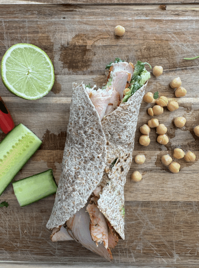 1-minute hummua wrap with deli turkey, lettuce, hummus, chickpeas, avocado, lime and cucumber.