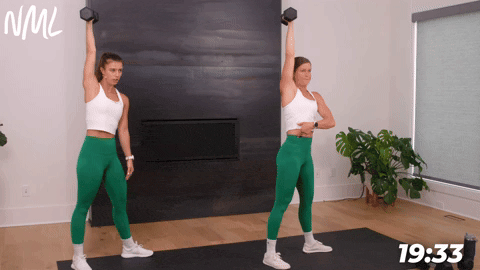 two women performing a dumbbell windmill in a dumbbell core workout