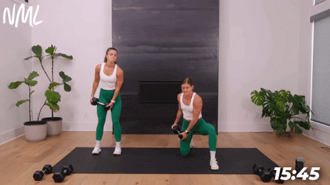 two women performing a woodchop in a dumbbell core workout