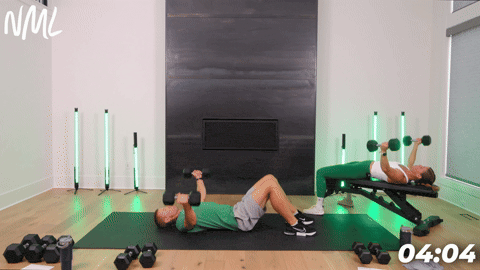A male performing a chest fly from the floor and a female performing chest fly laying on a bench.