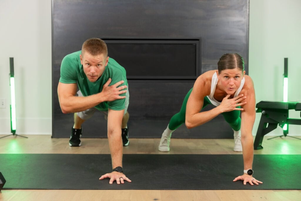 Male and female doing a push up shoulder tap.