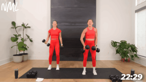 two women performing alternating bicep curls with dumbbells