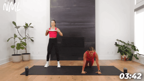 two women performing push ups on black exercise mat as part of five minute workout