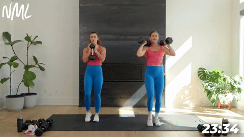 two women performing a dumbbell goblet march in a full body strength circuit workout