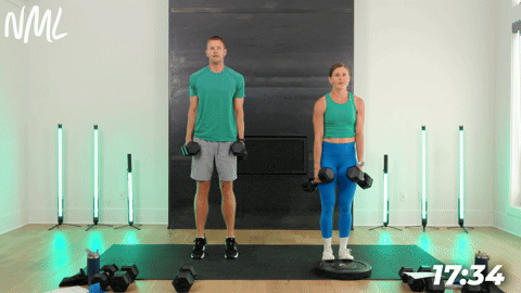 male doing standard Calf raises holding a dumbbell in each side and female doing Calf Raises on Plate Heels Elevated holding a dumbbell in each side.