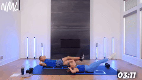 woman and man on black exercise mat performing hollow rock hold crunches