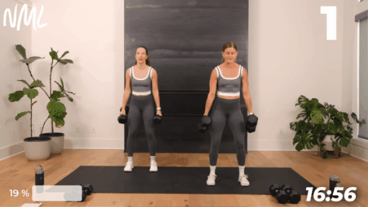 two women performing a squat as part of workout after illness