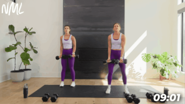 women performing a standing chest fly with dumbbells