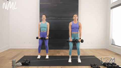 two women performing alternating front raises with dumbbells in an upper body workout