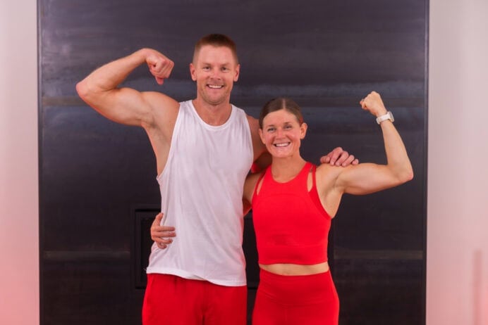 two people flexing biceps after completing an athletic workout at home