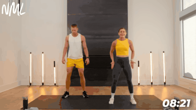 man and woman performing bodyweight squats to warm up the lower body before workout