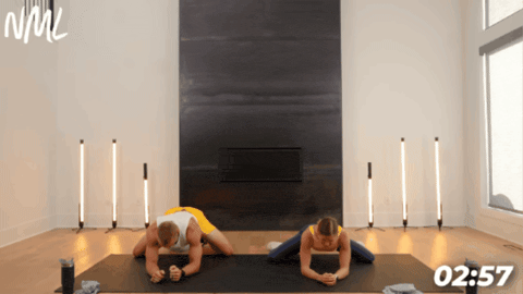 couple performing frog rocks as part of pre-workout stretching routine