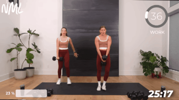two women performing a lateral lunge with one heavy dumbbell as part of full body workout in 30 mins