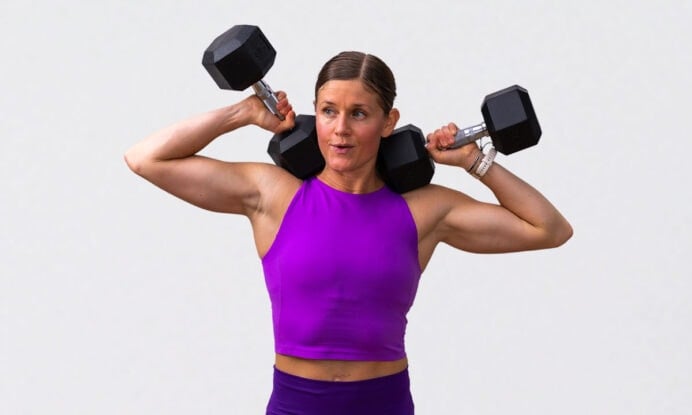 woman posing with dumbbells at shoulders after completing full body strength workout at home