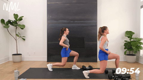 two women performing an isometric lunge hold in a quick leg workout