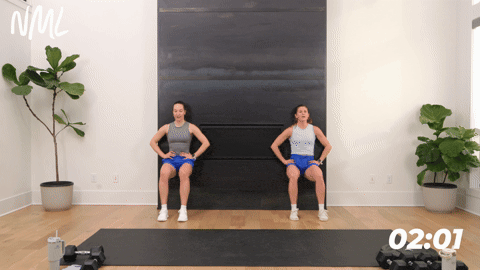 two women performing a wall sit in a quick leg workout at home