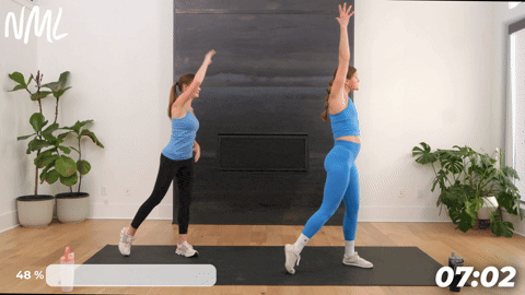 two women performing a side step arm sweep as part of the best lymphatic drainage exercises
