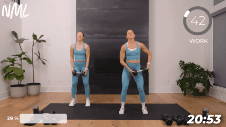women performing a dumbbell halo to target core from standing position
