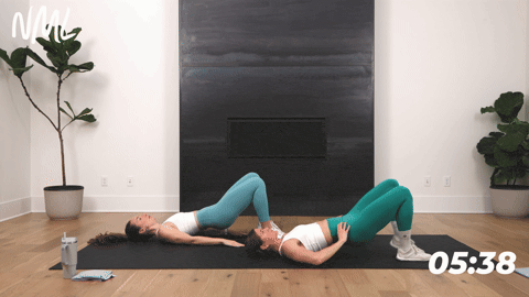 two women performing a glute bridge march in a beginner core workout