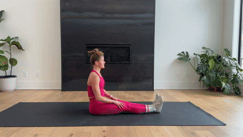 woman performing a hurdler stretch as part of the best hamstring exercises