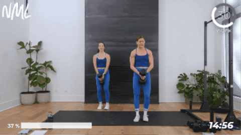 two women performing a lateral lunge with one heavy weight as part of legs and back workout