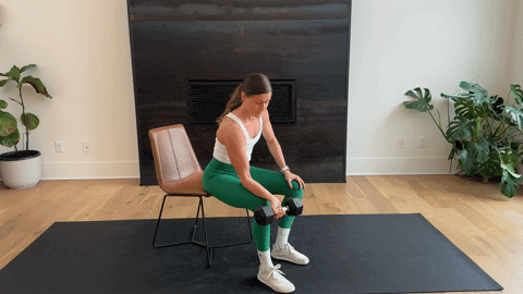 woman performing a palm up wrist curl with a dumbbell as part of the best forearm exercises