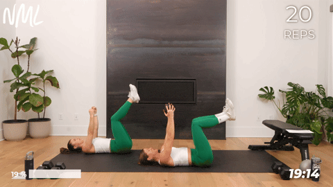 two women performing a dead bug in a core workout